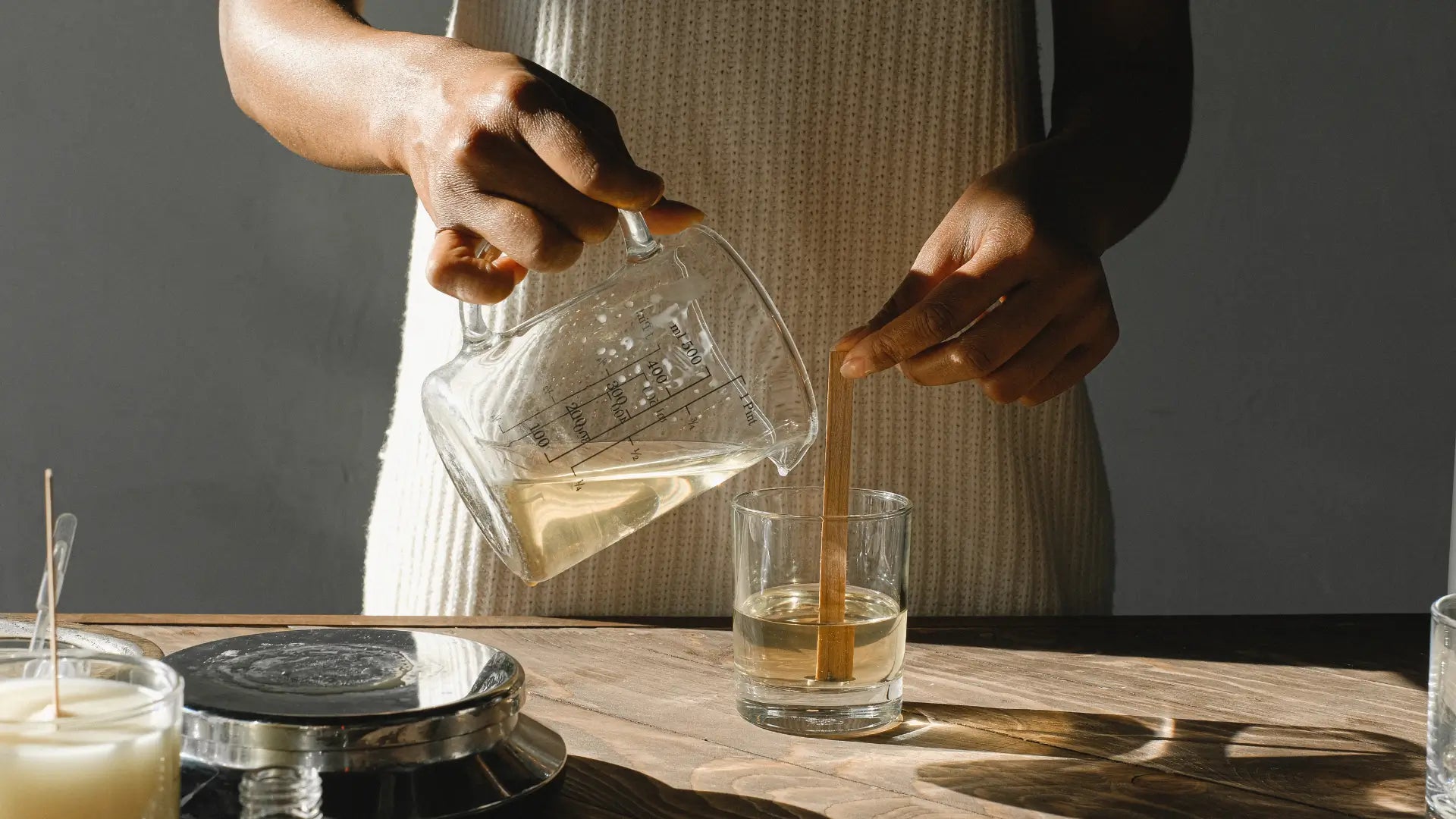 Vrouw die glas vult met honderd procent ecologische zonnebloemwas